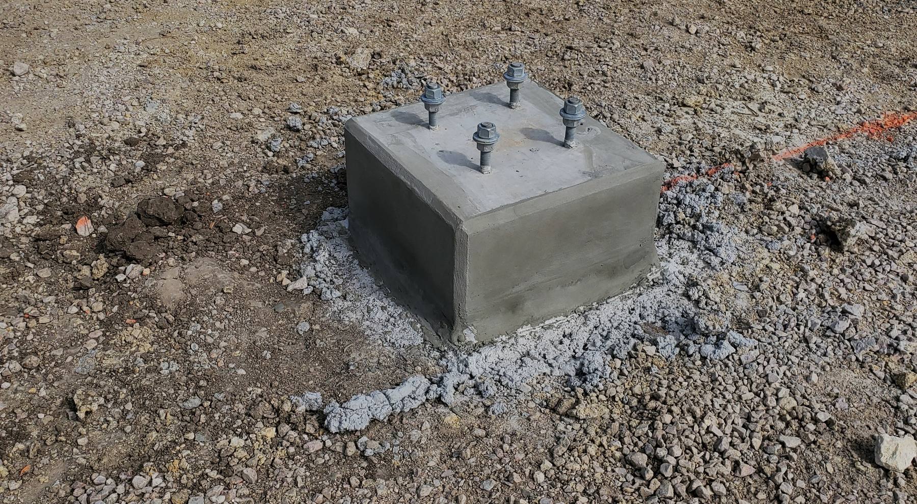 Concrete equipment pad footings with anchor bolts at an industrial site