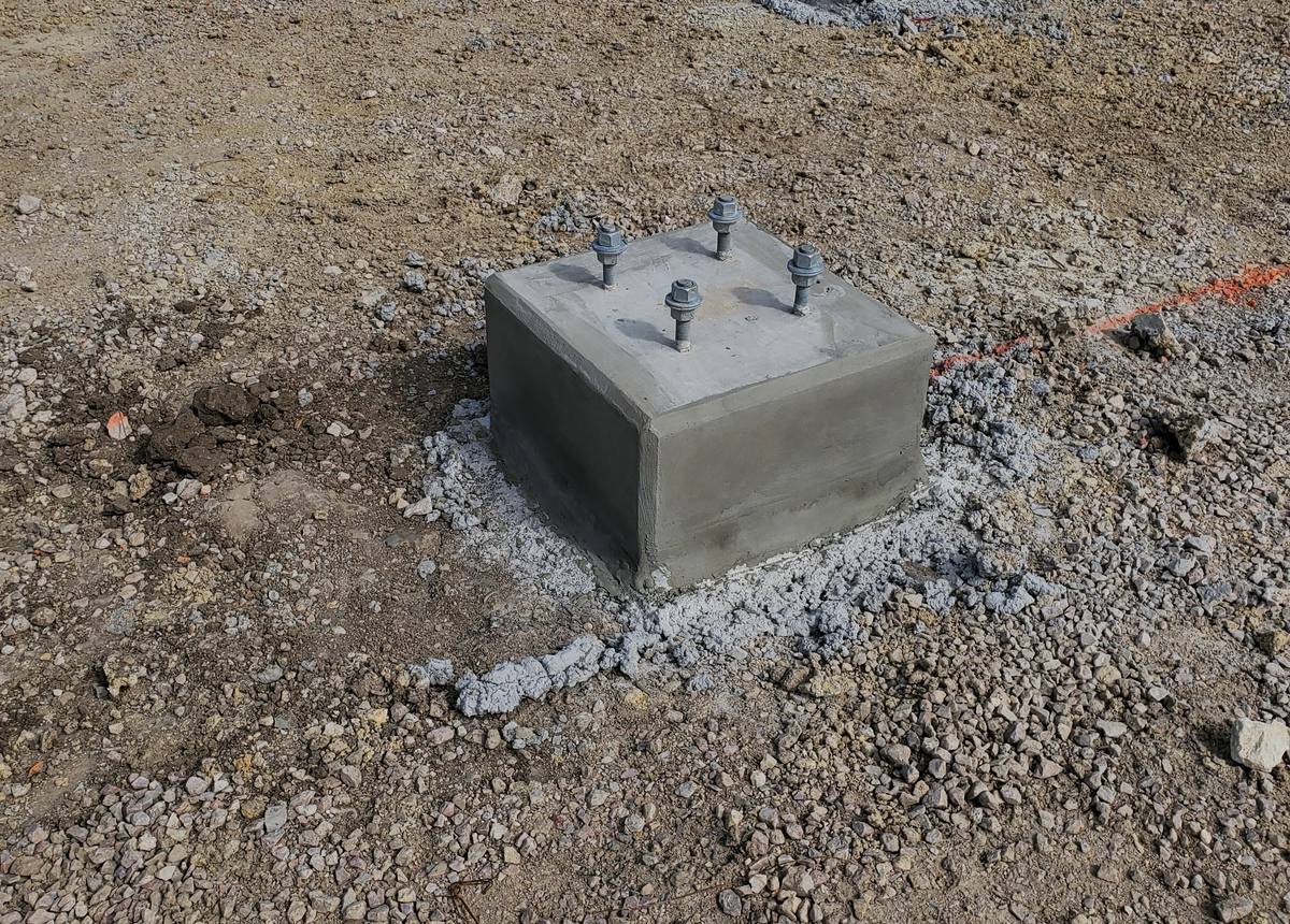 Concrete equipment pad footings with anchor bolts at an industrial site